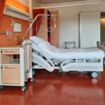 A clean and modern hospital room equipped with an adjustable bed and medical equipment.