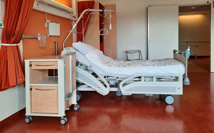 A clean and modern hospital room equipped with an adjustable bed and medical equipment.