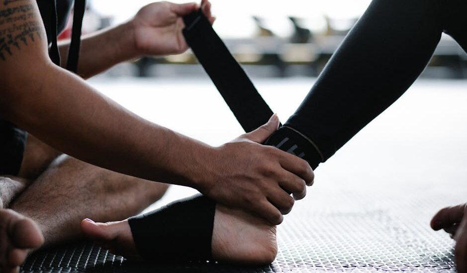 Close-up of a person wrapping an ankle brace on another's foot next to someone wearing a compression sock, illustrating ankle support options.