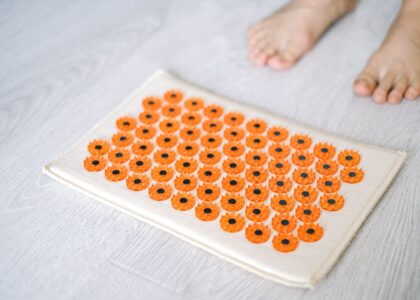 Close-up of a foot acupressure mat on a wooden floor, ideal for relaxation therapies.