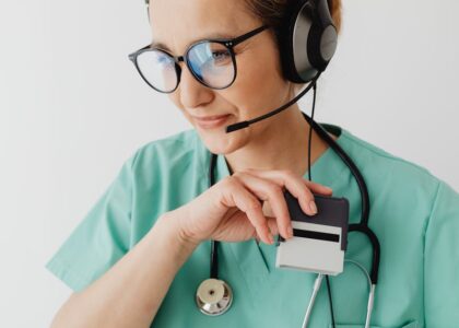 Medical professional with headset and stethoscope during a telemedicine consultation.