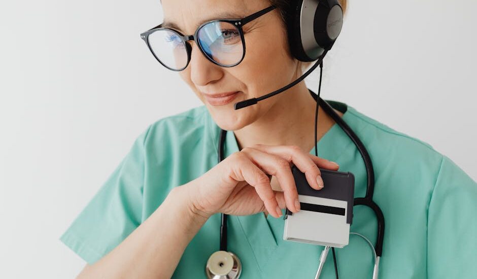 Medical professional with headset and stethoscope during a telemedicine consultation.