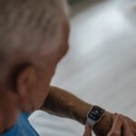 Older adult checking a smartwatch with health tracking features, illustrating fall detection devices for seniors in 2026