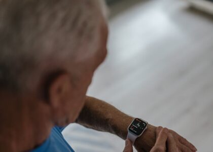 Older adult checking a smartwatch with health tracking features, illustrating fall detection devices for seniors in 2026