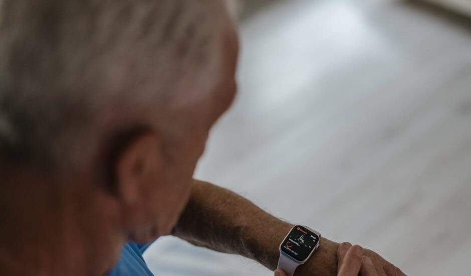 Older adult checking a smartwatch with health tracking features, illustrating fall detection devices for seniors in 2026