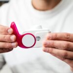 Close-up of hands holding a peak flow meter for respiratory health monitoring.