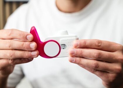 Close-up of hands holding a peak flow meter for respiratory health monitoring.