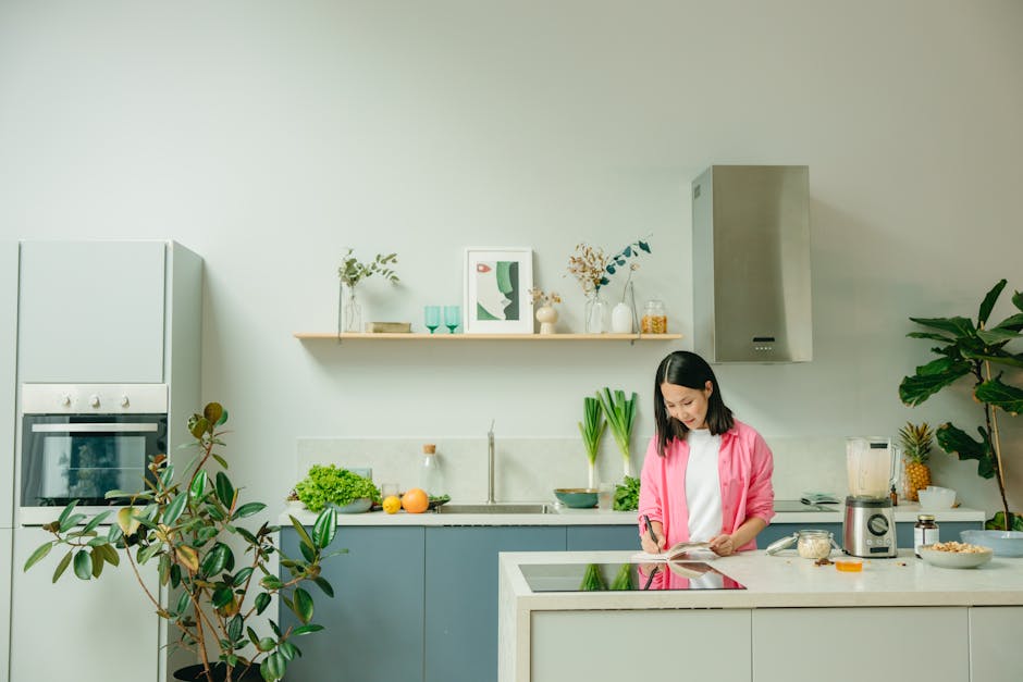 Asian woman chopping vegetables on a kitchen counter in a stylish, modern kitchen setting.