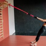 Woman using functional trainer in home gym setting for strength workout.