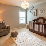 A cozy baby bedroom with a wooden crib, armchair, and soft lighting, illustrating an ideal space for using top humidifiers in 2026.