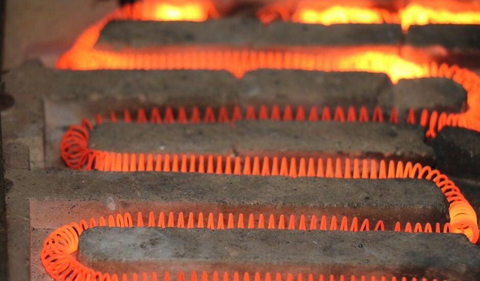 Detailed view of a glowing electric heating element with a coiled structure emitting heat.