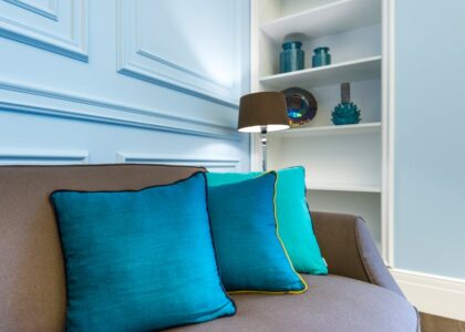 A stylish interior design showcasing a couch with vibrant turquoise accent pillows.