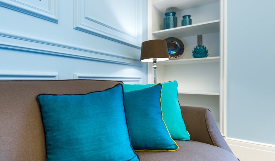 A stylish interior design showcasing a couch with vibrant turquoise accent pillows.