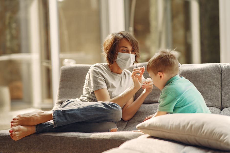 A mother wearing a face mask playing with her son on the sofa in a bright living room.