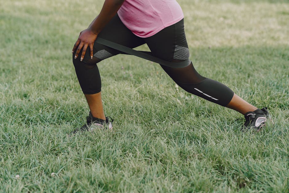 A woman performs resistance exercises outdoors, focusing on leg strength.