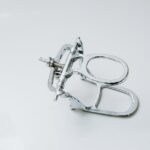 From above of metal dental occluder used for creating denture placed on white background