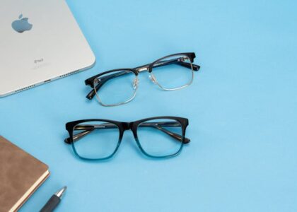 Stylish glasses and tech accessories arranged on a bright blue background, perfect for fashion and lifestyle themes.