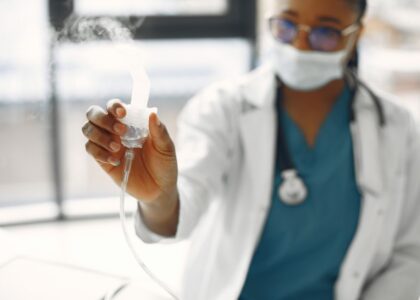 difference between steam inhalation and nebulization — Close-up of a healthcare worker holding a nebulizer, showing focus on medical equipment.