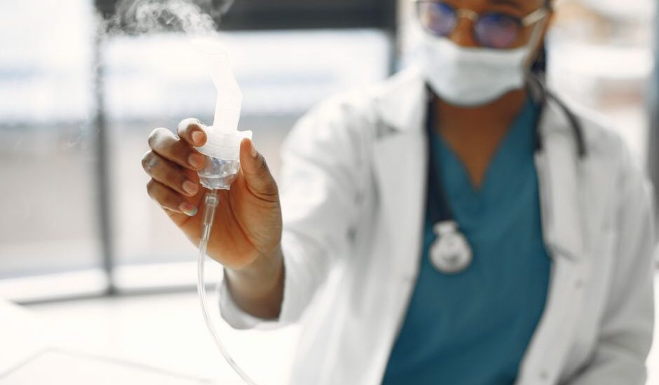 difference between steam inhalation and nebulization — Close-up of a healthcare worker holding a nebulizer, showing focus on medical equipment.
