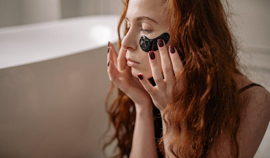 A woman applying black under eye masks, focusing on a beauty and skincare routine.
