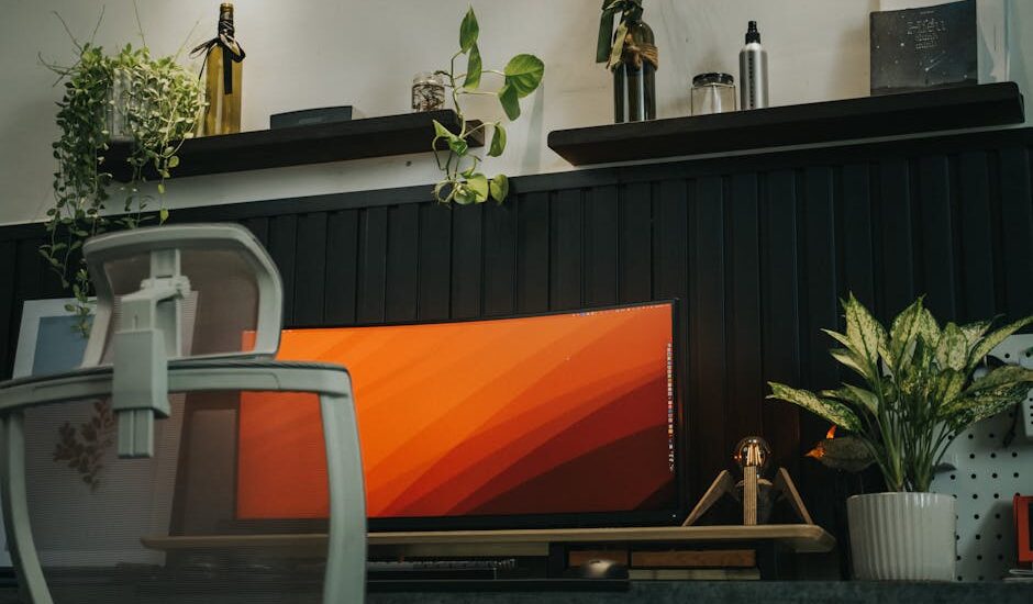 Stylish home office setup featuring a curved monitor, ergonomic chair, and indoor plants for a modern workspace vibe.