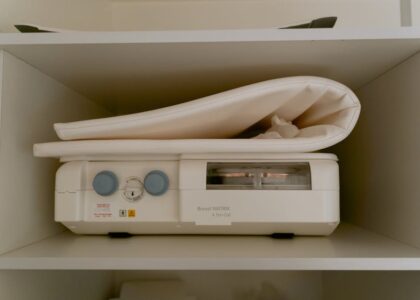A breast pump machine with control dials and a folded pad on a shelf, illustrating breast pump options for new parents.