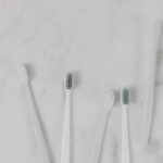 Top view of toothbrushes on a minimalist marble surface, perfect for hygiene themes.