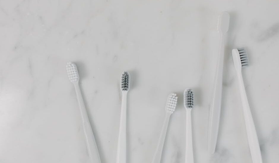 Top view of toothbrushes on a minimalist marble surface, perfect for hygiene themes.