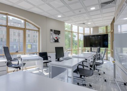 Contemporary minimalist office with glass windows and ergonomic chairs.