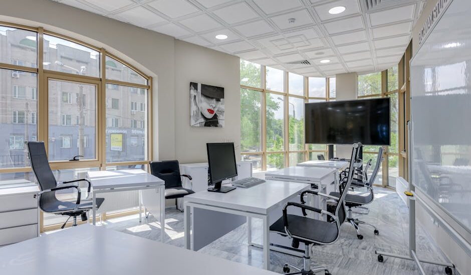 Contemporary minimalist office with glass windows and ergonomic chairs.