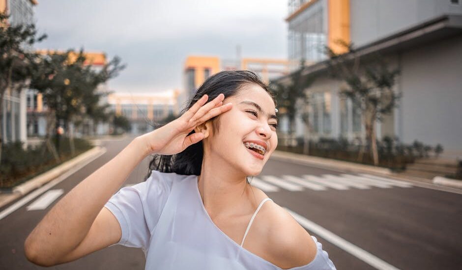 Happy woman with braces smiling on an urban street in daylight.