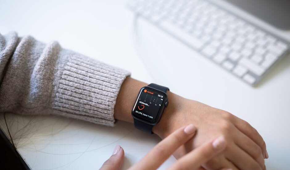 Person wearing an Apple Watch with a health tracking screen, relevant to comparing medical alert systems and smartwatches