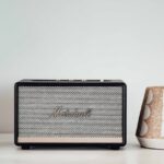 Marshall Bluetooth speaker alongside a ceramic holder on a modern table setup.