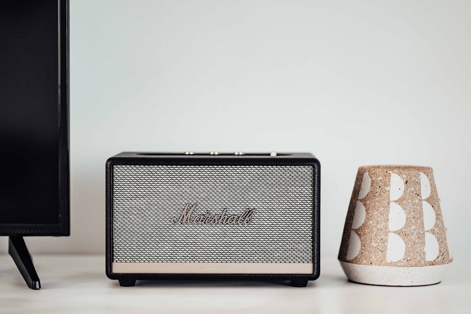 Marshall Bluetooth speaker alongside a ceramic holder on a modern table setup.
