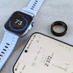 A smart ring, fitness band smartwatch, and smartphone with health data illustrate the smart ring vs fitness band topic.