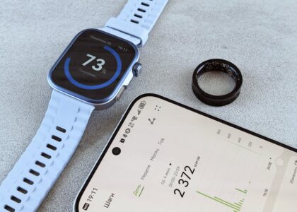 A smart ring, fitness band smartwatch, and smartphone with health data illustrate the smart ring vs fitness band topic.