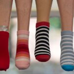A vibrant array of striped socks displayed on mannequin legs, showcasing fashion variety.