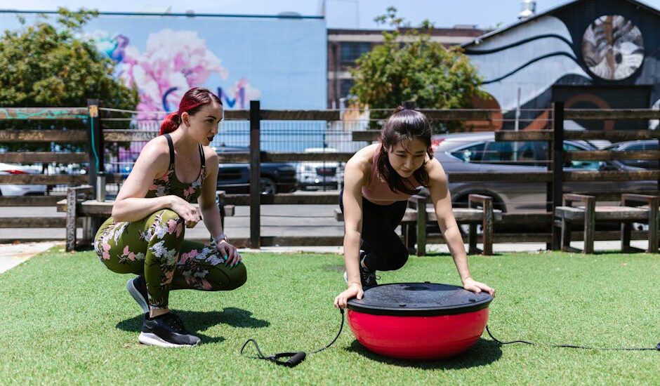 Two women exercising outdoors with a balance board, illustrating fitness equipment options for vibration plate vs balance board comparisons.