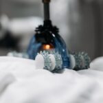 vibration therapy vs percussion therapy — High-tech massage gadget resting on white fabric, showcasing innovation in relaxation technology.