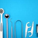 Dental cleaning tools including a water flosser tip, dental picks, and toothbrushes arranged for a water flosser vs dental pick article