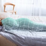 Relaxing scene of a woman peacefully sleeping under a cozy weighted blanket in a serene bedroom.