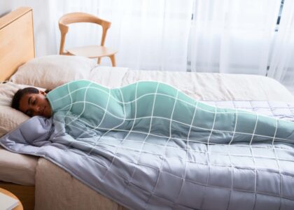 Relaxing scene of a woman peacefully sleeping under a cozy weighted blanket in a serene bedroom.