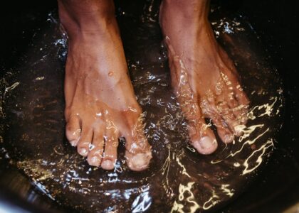 Close-up of male feet soaking in water for a relaxing spa treatment.