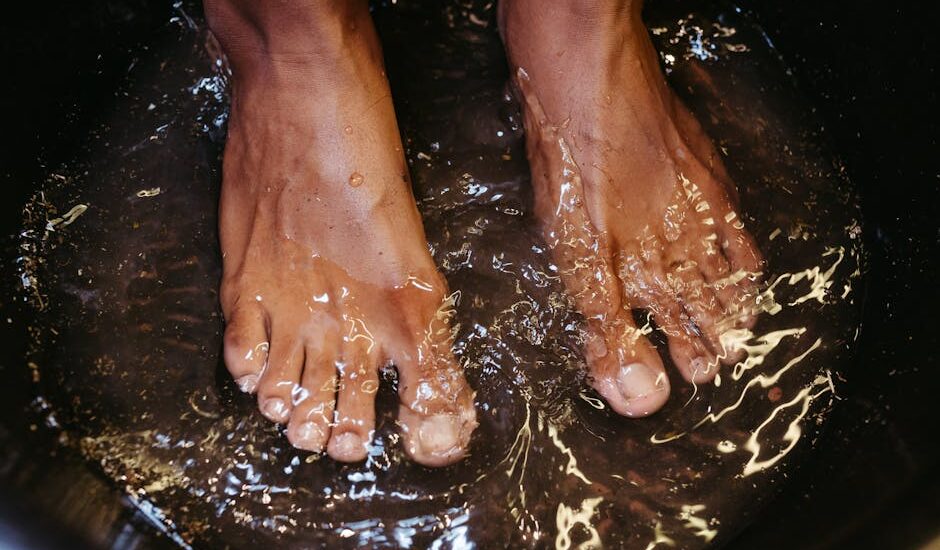 Close-up of male feet soaking in water for a relaxing spa treatment.