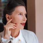 Portrait of an elegant senior woman with red lips and manicured nails, embodying grace and confidence.