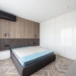 Spacious modern bedroom with minimalist design and wooden accents.