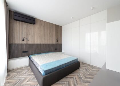 Spacious modern bedroom with minimalist design and wooden accents.