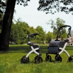 Two adjustable rollator walkers with seats on grass, illustrating mobility aids.