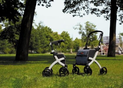 Two adjustable rollator walkers with seats on grass, illustrating mobility aids.