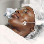 A woman receiving a microcurrent facial treatment, related to safety of such procedures.